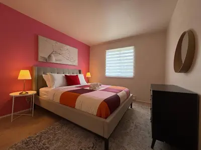a bedroom with a bed with red walls and a window at Montreal & Free Parking Comfy Cozy Pierrefonds Apts in Montréal