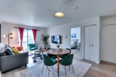 a living room with a table and chairs and a couch at Montreal & Free Parking Comfy Cozy Pierrefonds Apts in Montréal