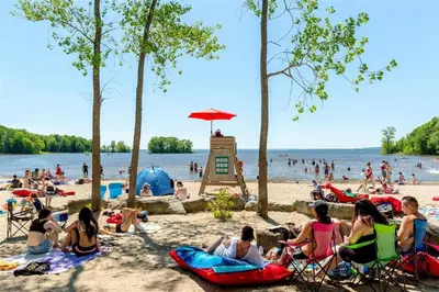 a group of people sitting on a beach at Montreal & Free Parking Comfy Cozy Pierrefonds Apts in Montréal