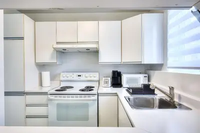 a kitchen with white cabinets and a stove and a sink at Free Parking! Family & Travel Comforts! Montreal & Downtown Adventures! in Montréal