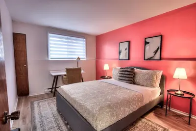 a bedroom with a red wall with a bed and a desk at Free Parking! Family & Travel Comforts! Montreal & Downtown Adventures! in Montréal