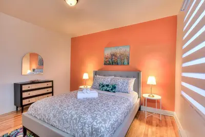 a bedroom with a bed with an orange wall at NDG & Montreal getaway in Montréal