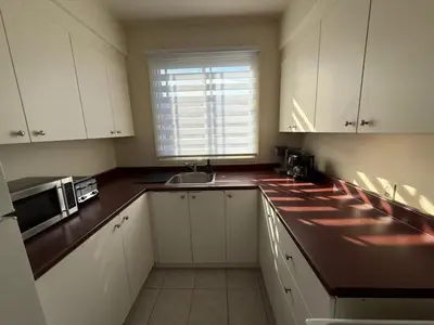 a kitchen with white cabinets and a sink and a window at NDG & Montreal getaway in Montréal