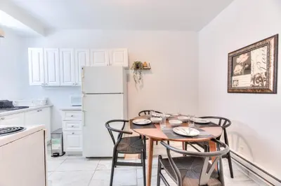 a kitchen with a table with chairs and a refrigerator at NDG & Montreal getaway in Montréal