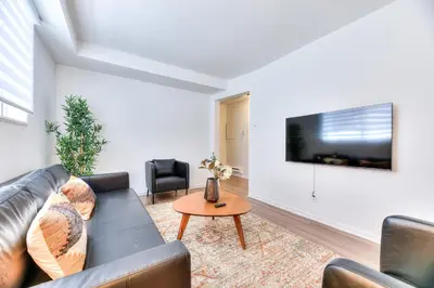 a living room with a couch and a tv on a wall at NDG & Montreal getaway in Montréal