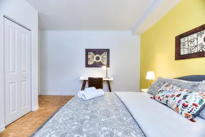 a bedroom with a king sized bed and yellow walls at NDG & Montreal getaway in Montréal