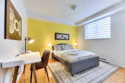 a bedroom with a bed and a desk and a window at NDG & Montreal getaway in Montréal