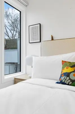 a bedroom with a white bed and a window at Le Mistral Modern Studios in Montréal