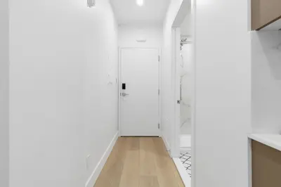 a hallway with white walls and a white door at Le Mistral Modern Studios in Montréal