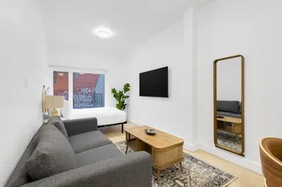 a living room with a couch and a mirror at Le Mistral Modern Studios in Montréal