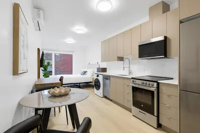 a kitchen with a table and a living room at Le Mistral Modern Studios in Montréal