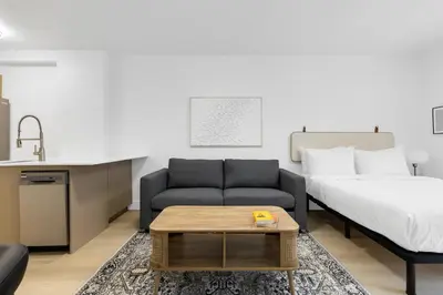 a living room with a couch and a bed at Le Mistral Modern Studios in Montréal