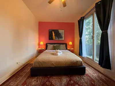 a bedroom with a bed with red walls and a window at NDG Montreal! Attractions & Downtown Adventure Travels! Family, Friends, Work-travel! in Montréal