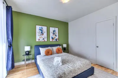 a bedroom with a bed and a green wall at NDG Montreal! Attractions & Downtown Adventure Travels! Family, Friends, Work-travel! in Montréal