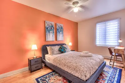 a bedroom with orange walls and a bed and a window at NDG Montreal! Attractions & Downtown Adventure Travels! Family, Friends, Work-travel! in Montréal