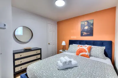 a bedroom with a blue bed and an orange wall at Your Montreal Home Base! Free parking Free Wifi in Montréal