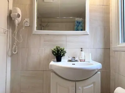 a bathroom with a white sink and a mirror at Your Montreal Home Base! Free parking Free Wifi in Montréal
