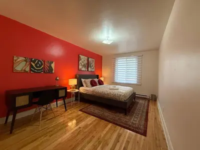 a bedroom with red walls and a bed and a desk at Your Montreal Home Base! Free parking Free Wifi in Montréal