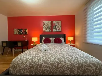 a bedroom with a large bed with a red wall at Your Montreal Home Base! Free parking Free Wifi in Montréal