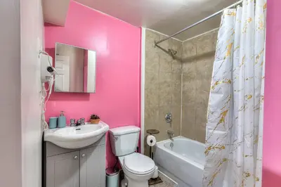 a pink bathroom with a toilet and a sink at Your Montreal Home Base! Free parking Free Wifi in Montréal