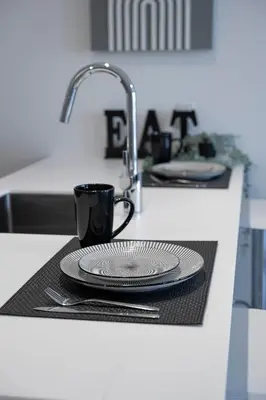 a kitchen counter with a sink with plates and a coffee cup at Panoramic Skyline Penthouse Montreal Downtown -Free Parking - In Suite Laundry in Montréal