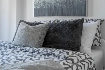a bed with black and white pillows on it at Panoramic Skyline Penthouse Montreal Downtown -Free Parking - In Suite Laundry in Montréal