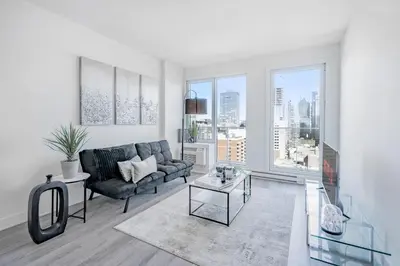 a living room with a couch and a table at Panoramic Skyline Penthouse Montreal Downtown -Free Parking - In Suite Laundry in Montréal