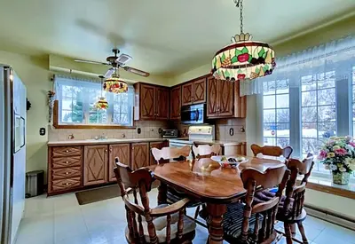 a kitchen with a wooden table and chairs and a chandelier at 2beds in Room A Free parking 15min to downtown in Longueuil