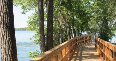 a wooden bridge over a body of water at Riverside stay, 2 bedrooms, 1 office, free parking in Montréal