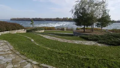 a grassy yard with a path next to a lake at Riverside stay, 2 bedrooms, 1 office, free parking in Montréal