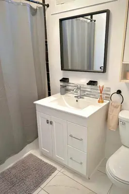 a white bathroom with a sink and a shower at Riverside stay, 2 bedrooms, 1 office, free parking in Montréal