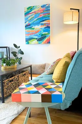 a living room with a couch and a colorful ottoman at Riverside stay, 2 bedrooms, 1 office, free parking in Montréal
