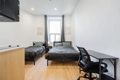 a room with two beds and a desk and a table at Central Studio For 3 Guest With Parking in Montréal