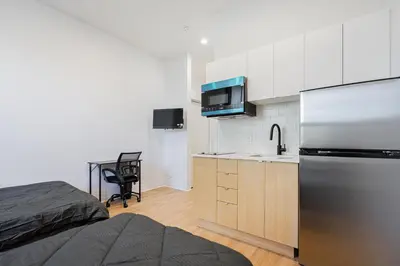a small kitchen with a refrigerator and a sink at Central Studio For 3 Guest With Parking in Montréal