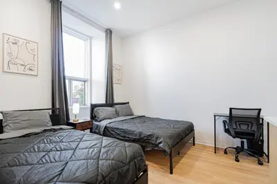 a bedroom with two beds and a desk and a chair at Central Studio For 3 Guest With Parking in Montréal