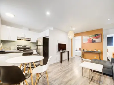 a kitchen and living room with a table and chairs at Appartement design au cœur de Griffintown in Montréal