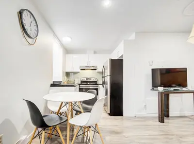 a kitchen with a table and chairs and a clock on the wall at Appartement design au cœur de Griffintown in Montréal