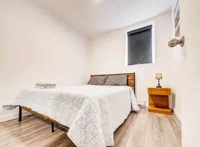 a white bedroom with a bed and a window at Appartement design au cœur de Griffintown in Montréal