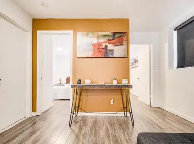 a living room with a table in front of a wall at Appartement design au cœur de Griffintown in Montréal