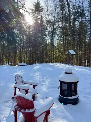 a snow covered picnic table and a grill in the snow at Pur Nature Garthby et Sauna in Saint-Gérard