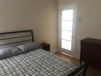 a bedroom with a bed and a window and a door at Le Loft des Milles-Îles in Laval