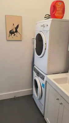 a washer and dryer in a bathroom with a sink at Le Loft des Milles-Îles in Laval