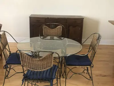 a glass table with chairs and a wooden cabinet at Le Loft des Milles-Îles in Laval
