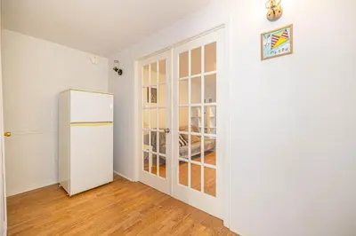 a white refrigerator in a room with a door at Cozy 1 BDR apt in MTL-E, near metro, free parking in Montréal