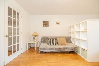 a white bedroom with a bed and a table at Cozy 1 BDR apt in MTL-E, near metro, free parking in Montréal