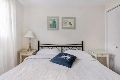 a bedroom with a bed with a blue pillow on it at Voltaire 1 Apartement 4,5 2ch Laval, Canada in Laval