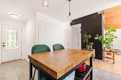 a dining room with a wooden table and green chairs at Chalet La Dinette in Stanbridge Station
