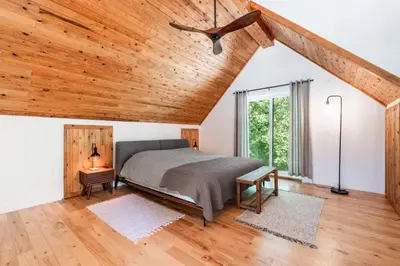 a bedroom with a bed and a wooden ceiling at Chalet La Dinette in Stanbridge Station