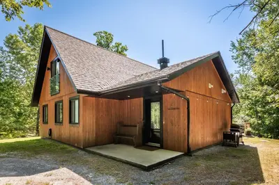 a large wooden house with a porch at Chalet La Dinette in Stanbridge Station