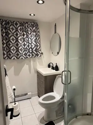 a bathroom with a toilet and a sink and a shower at Entire Urban Cabin Retreat 3BD Terrace&Covered Parking in Terrebonne